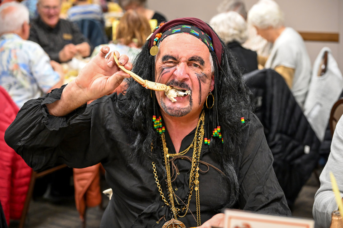 Dave Tosch dressed as a pirate, eating a crab leg